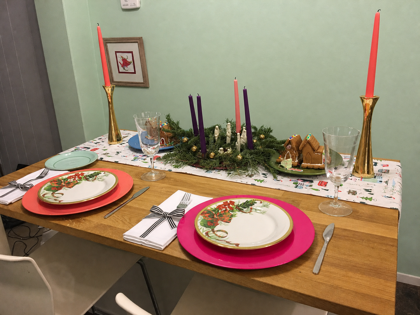 Christmas table with hot pink and coral chargers, mint plates, purple and rose Advent candles, and gold candleholders