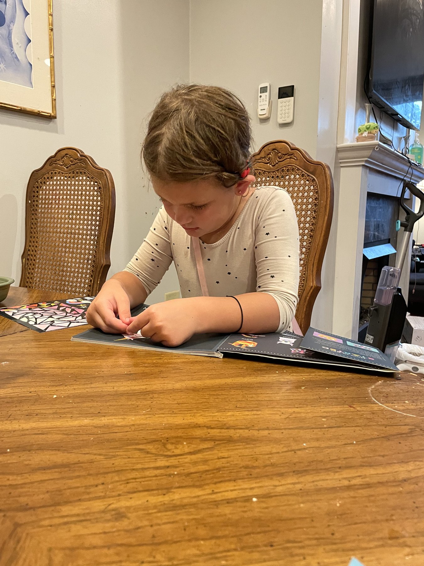 A child completes an art activity at the family dining table.