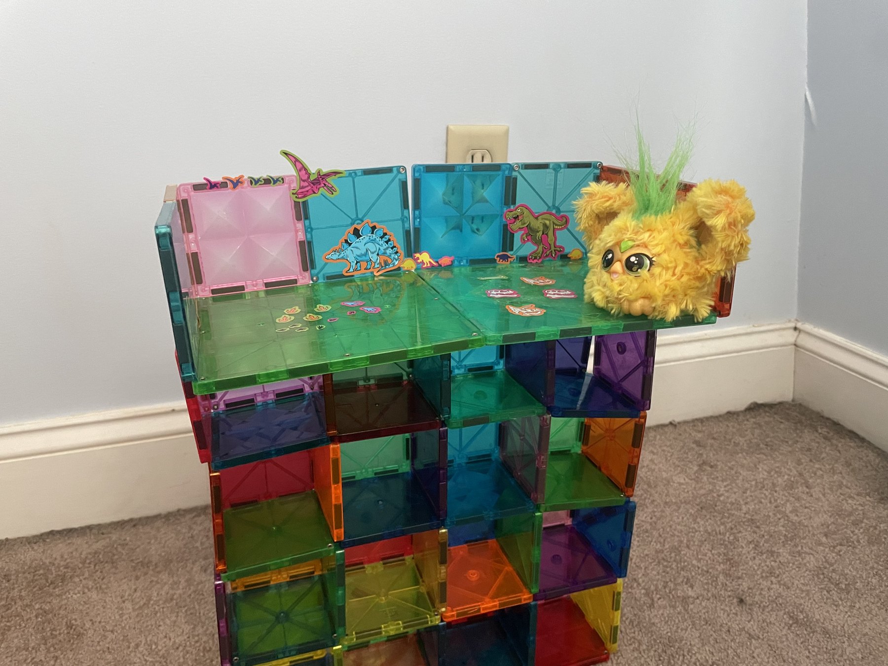 A detailed magnetic-tile building and toy scene made while a young student was expected to be doing schoolwork.