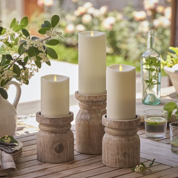 Three ivory outdoor pillar candles in graduated heights.